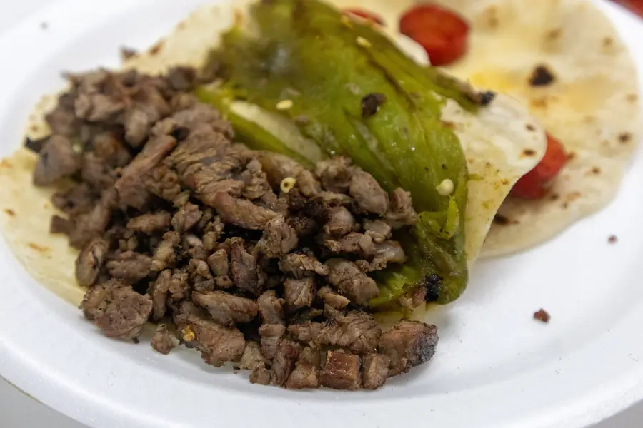 Tacos de carne asada servidos con salsa y cebolla