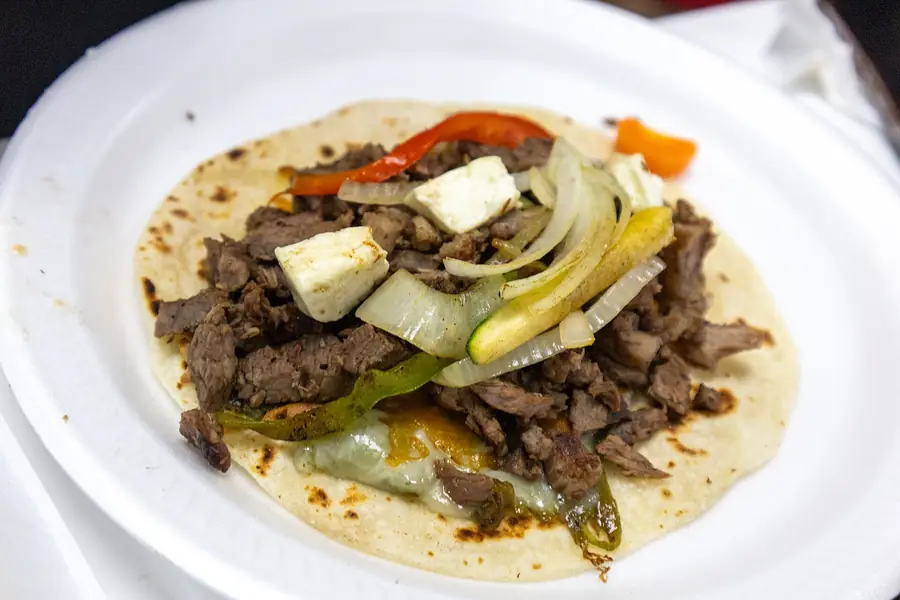 Orden de tacos recién armados con cilantro y cebolla